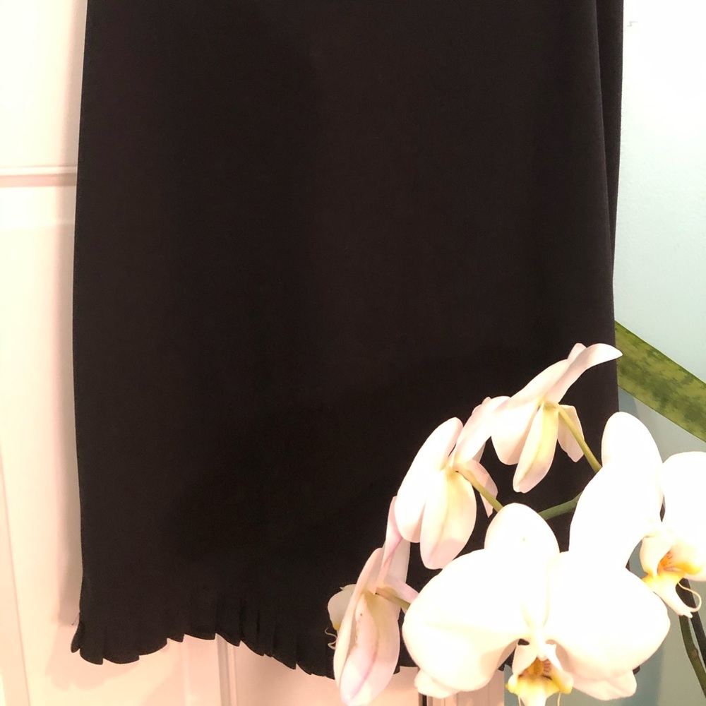 Black skirt with ruffle pleated detail at hem.